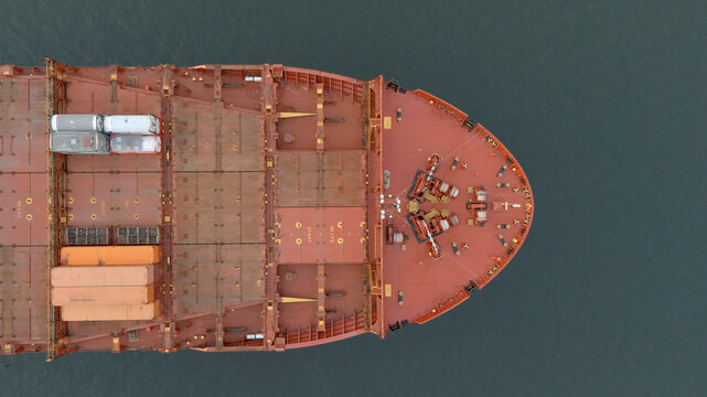 Aerial straight down view of the bow of an empty cargo ship at sea.