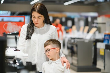 Fototapeta na wymiar Happy mother with son in home appliance store.