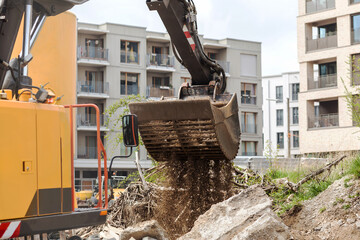 Construction waste. Excavator loading demolition debris and concrete waste for recycling at...