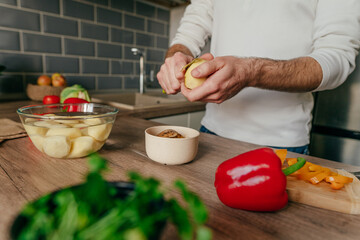 Unrecognizable man cooking vegetables in the kitchen