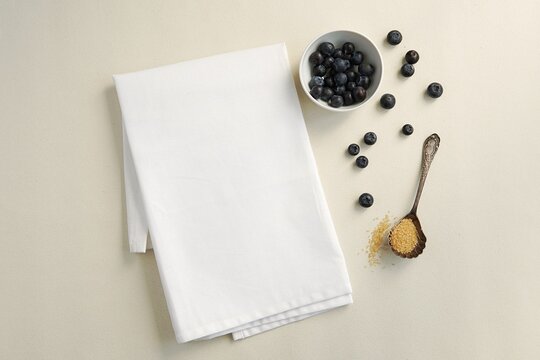 White cotton kitchen towel mockup for design presentation, blank tea towel mock up on table with blueberries.