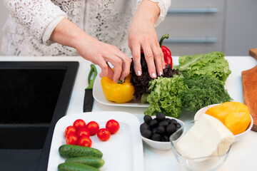 Hands of an elderly retired woman preparing ingredients vegetables for cooking in the kitchen