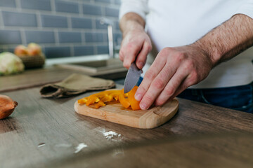 Unrecognizable man cooking vegetables in the kitchen