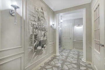 Stylishly decorated corridor with an original painting on the wall. Ceramic tile with a pattern on the floor.
