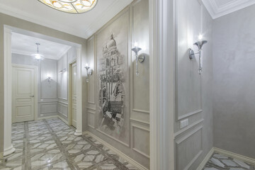 A luxurious bright corridor with stylish lamps, beautiful floor tiles with a pattern and an author's picture painted on the wall. Neoclassical interior design