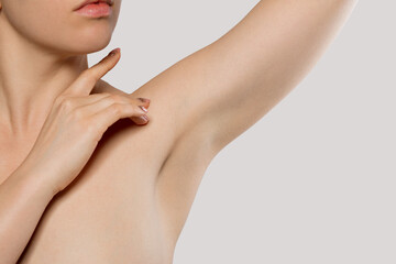 Skin care. Armpit epilation, laser hair removal. Young woman holding her arms up and showing clean underarms.