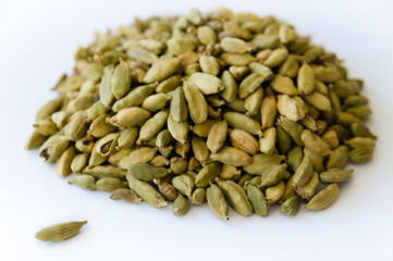 Heap of dry green cardamons on a white background