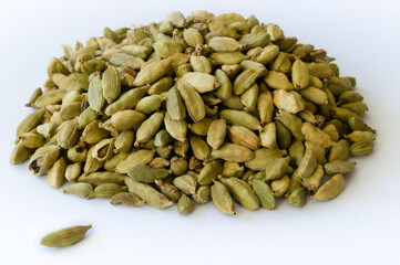 Heap of dry green cardamons on a white background