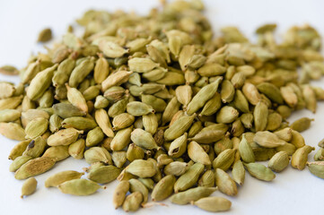 Heap of dry green cardamons on a white background