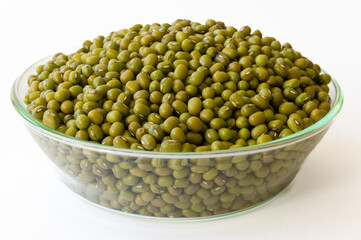 Mung beans in a glass bowl on a white background