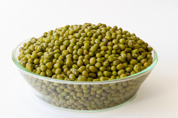Mung beans in a glass bowl on a white background