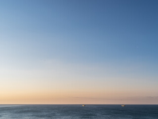 Calm sea and cloudless orange evening sky.