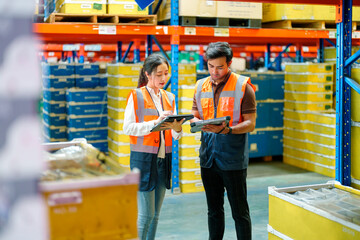 Warehouse workers discussing on shipping schedule in manufacturing warehouse.