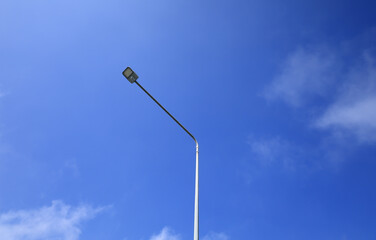 Street light poles and blue sky background.