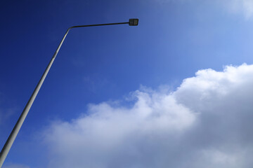 Street light poles and blue sky with cloud.