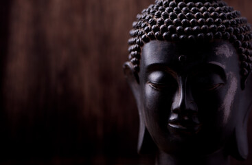 Meditating Buddha Statue on dark background. Soft focus. Close up. Copy space.	