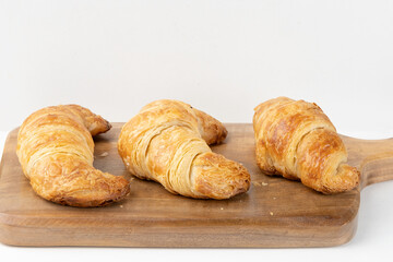 Triple croissant on cutting board. Selective focus.