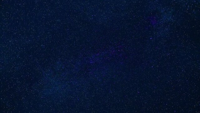 beautiful timelapse of starry night blue sky with the Milky way and lots of falling shining stars
