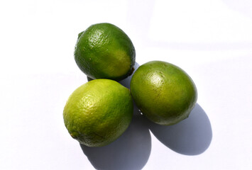 Three limes on white background close up.