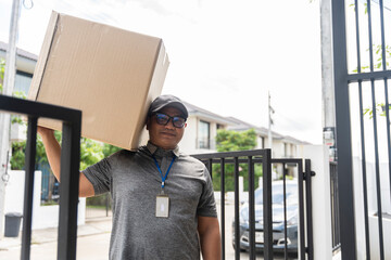 delivery man holding a large box to send to customers in front of the house