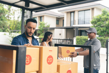 A couple is picking up goods from a delivery man at home. checking product