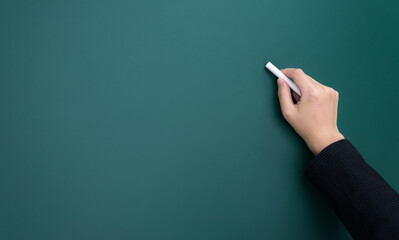 Businesswoman hand writing chalk on blackboard
