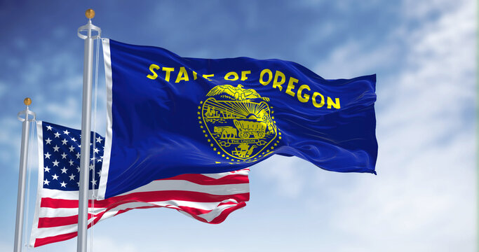 The Oregon state flag waving along with the national flag of the United States of America