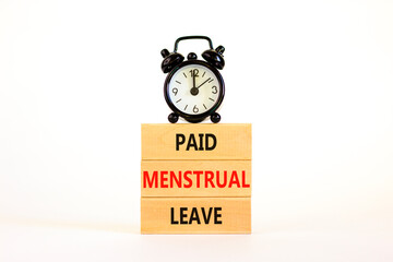 Paid menstrual leave symbol. Concept words Paid menstrual leave on wooden blocks. Black alarm clock. Beautiful white table white background. Business medical paid menstrual leave concept. Copy space.