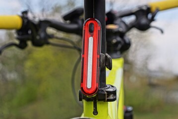 one red long plastic warning light on a black yellow sports bike in the street