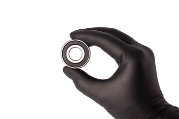 Male hand in nitrile glove holding metal roller bearing. Ball bearing isolated. Super Precision...