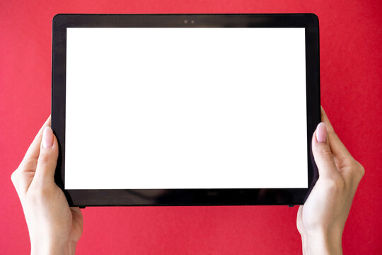 Computer mockup. Online education. Digital technology. Unrecognizable woman holding tablet computer in hands with blank screen isolated red.