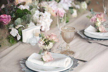 Obraz na płótnie Canvas Delicate wedding table setting. A plate with a napkin and a rose.