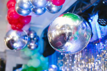 Shiny disco ball and inflatable balloons at the party