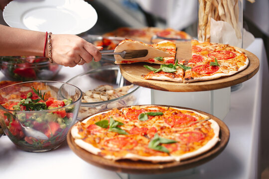 Self-service at the buffet. A variety of pizza and salads.