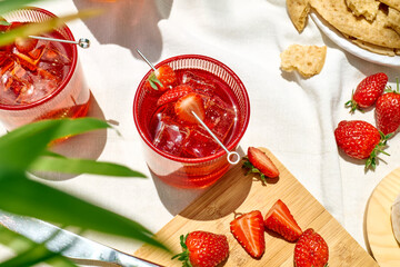 Cozy spring or summer breakfast or brunch outside on the table. Strawberry mocktail, camembert cheese, flat crispbread on linen tablecloth. Healthy snack. Picnic.