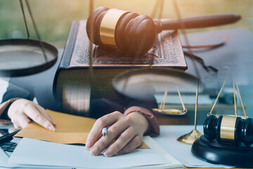 Justice and law concept.Male judge in a courtroom with the gavel, working with, computer and...