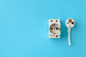 Burnt electrical wire plug and din socket after short circuit. The concept of electrical safety....