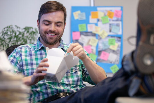 Bearded man with take away food in office