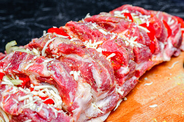Loin meat with spices, cut into pieces, lies on a cutting board for further cooking on a fire or in the oven.