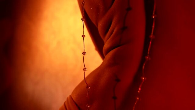 naked back of young sexy woman dancing in intimate atmosphere, closeup view, wriggling body