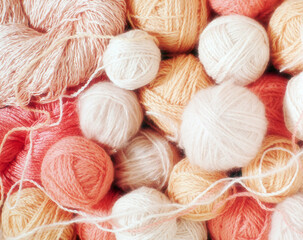 balls of pink wool in various shades, forming a soft and harmonious background
