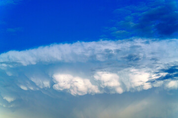 Heaven and infinity. Summer sky. Beautiful bright blue background. White clouds in the blue sky. Light cloudy, good weather. Curly clouds on a sunny day