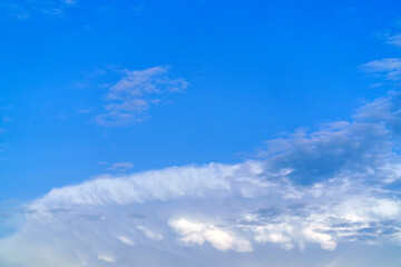 Heaven and infinity. Curly clouds on a sunny day. White clouds in the blue sky. Light cloudy, good weather. Summer sky. Beautiful bright blue background