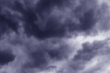 Obraz premium Cloudy clouds on a rainy day. Gray clouds in the dark sky. Beautiful background. Stormy summer sky. Strong cloud cover, bad weather. A storm warning. Heaven and infinity