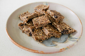 plate with cut up homemade date and oat granola bars on ceramic plate