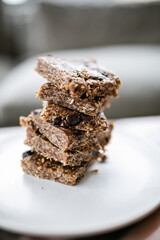 Stack of homemade no-bake date and oat granola bars with chocolate chunks