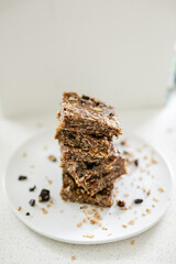 Stack of homemade no-bake date and oat granola bars with chocolate chunks