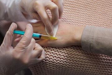 Doctor doing stem cell therapy on a patient's elbow after the injury. Treating knee pain with...