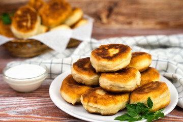 Hot homemade fried pies with potatoes and meat on the wooden table. Delicious homemade food. Close-up.