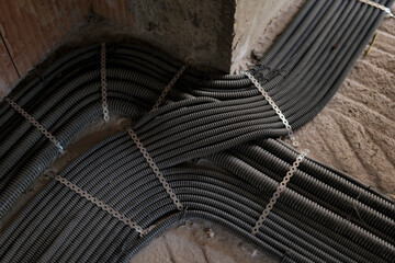 Fototapeta na wymiar Electrical installations with wires and conductors on brick wall on a construction site